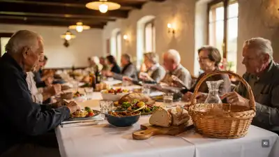 Familienessen an langer Tafel mit Brotkorb, Speisen und Glaskaraffe im rustikalen Raum mit Rundbogenfenstern.